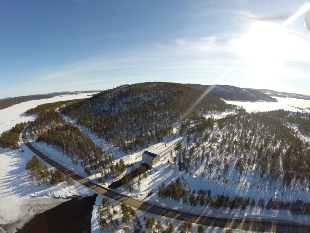 Arkistokuva Kirakan vesivoimalaitoksesta aurinkoisena kevättalvisena päivänä. Kuvan keskellä on voimalaitos, yläosassa vielä jään peittämä Rahajärvi. Alaosassa kaarevasti kuvatun alueen läpi kulkeva 4-tie siltoineen ja alimpana Ukonjärveen laskevaa voimalaitosvirtaa. 